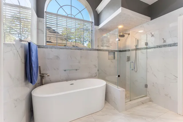 a bedroom with furniture and a large window