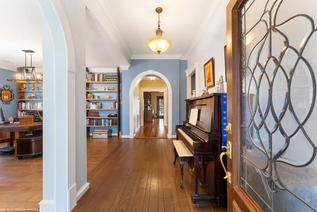 a living room with furniture lots of books and a large window
