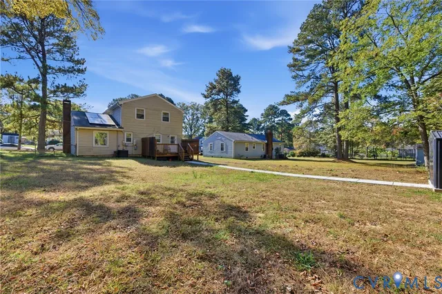 a front view of house with yard and trees in the background
