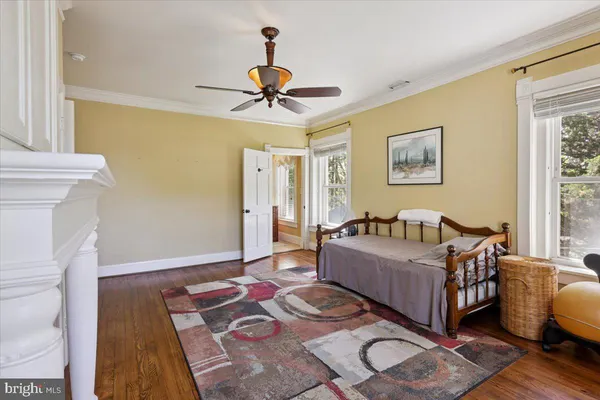 a living room with a bed and a table with wooden floor