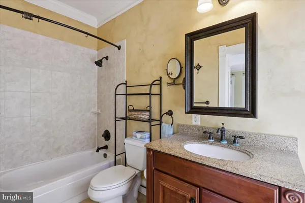 a bathroom with a granite countertop sink toilet mirror and shower