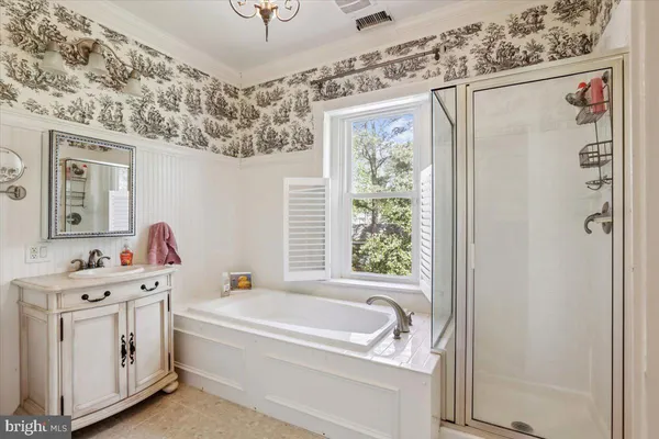 a bathroom with a tub sink and mirror