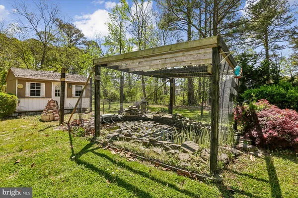 a view of a patio with table and chairs plants and large trees