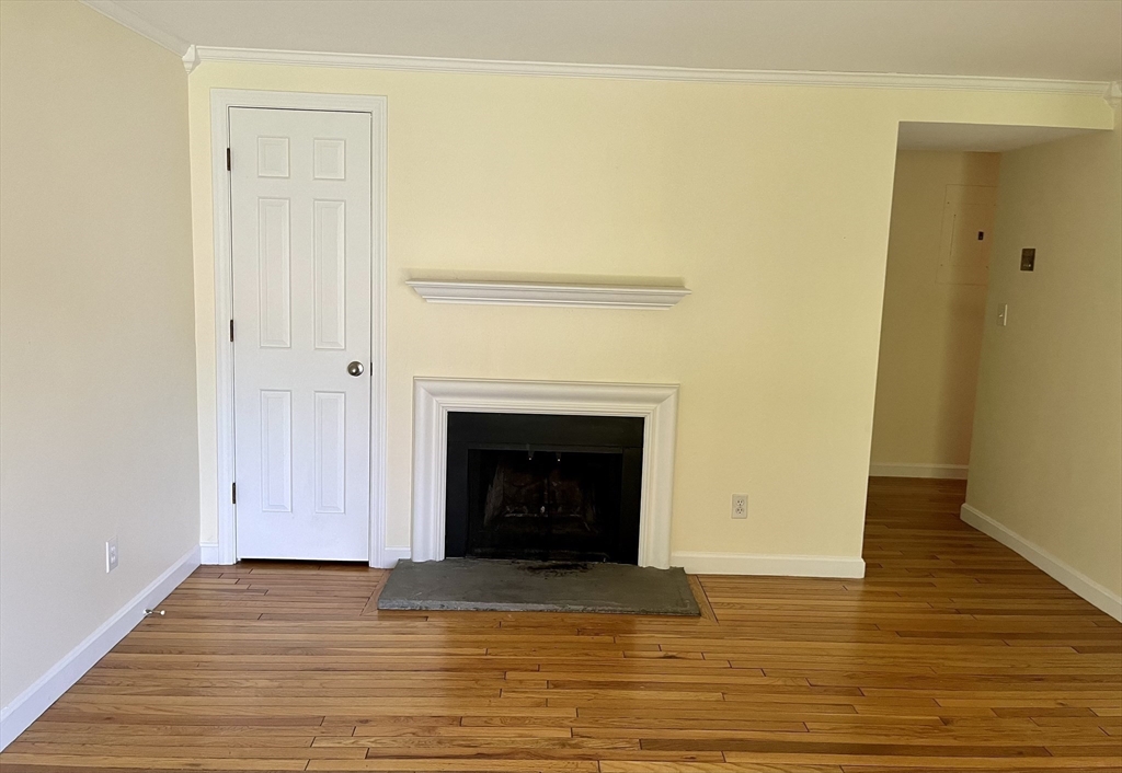 53 Jericho Road, Unit A Weston, MA 02493 - Photo 3 of 16 a view of empty room with wooden floor and fireplace