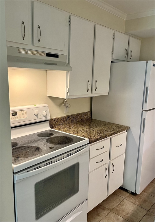 53 Jericho Road, Unit A Weston, MA 02493 - Photo 8 of 16 a kitchen with granite countertop white cabinets and white appliances