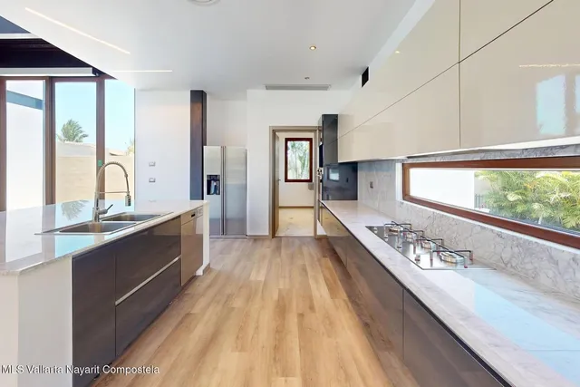a view of kitchen with kitchen island wooden floor and stainless steel appliances