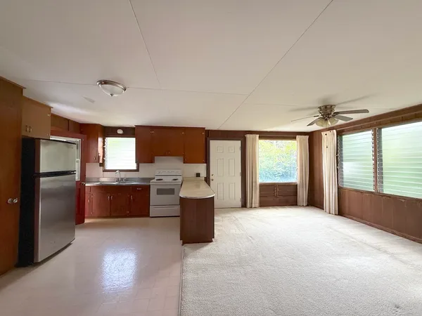 a large open kitchen with a large window and stainless steel appliances