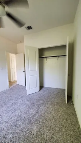 an empty room with a window and a fan