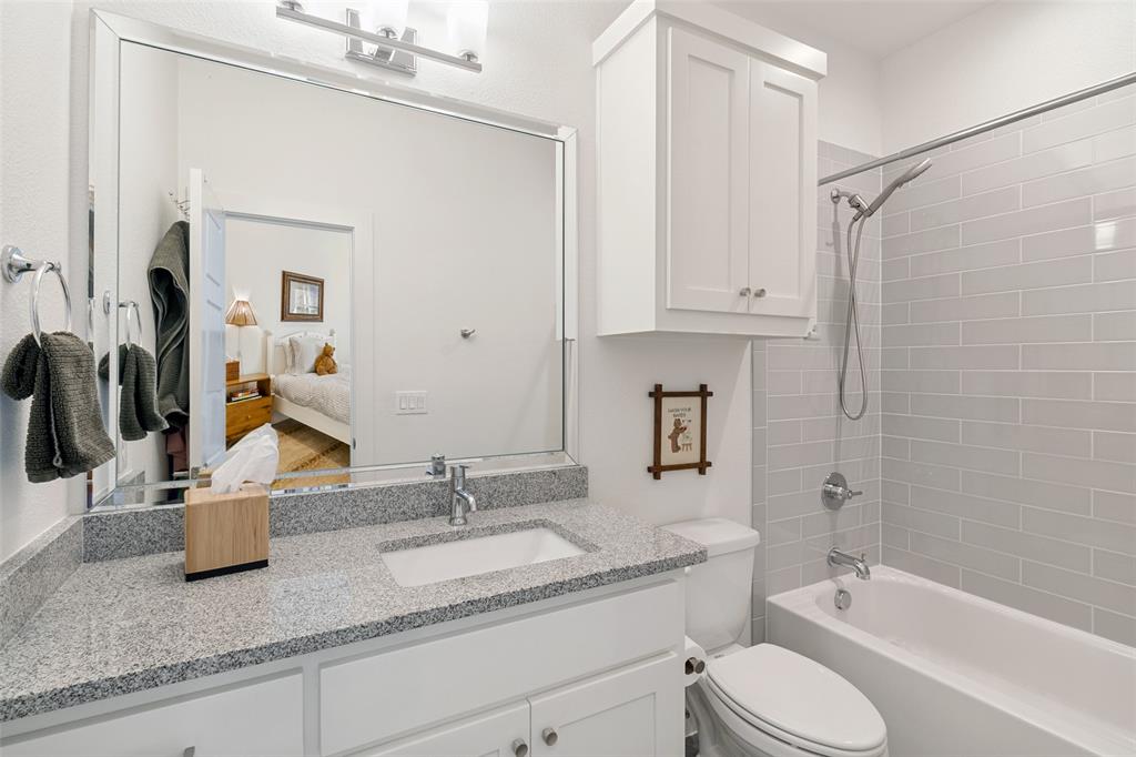 7533 Garonne Street Dallas, TX 75231 - Photo 22 of 32 a bathroom with a granite countertop sink toilet and shower