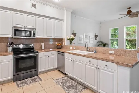a kitchen with stainless steel appliances granite countertop a sink a stove a microwave and cabinets