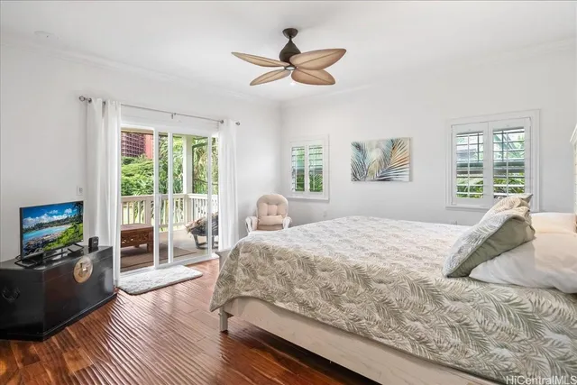 a bedroom with a large bed a large window and wooden floor