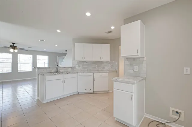 a kitchen with granite countertop white cabinets and white appliances