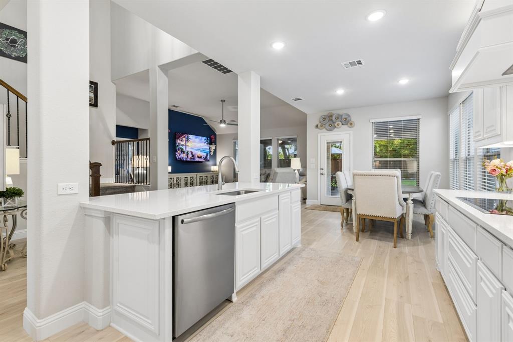 1023 Ridgehurst Road Melissa, TX 75454 - Photo 14 of 39 Open-concept kitchen featuring an expansive island with white cabinetry, a stainless steel dishwasher, and a single-basin sink with a gooseneck faucet