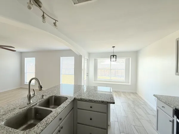 a kitchen with sink a window and refrigerator