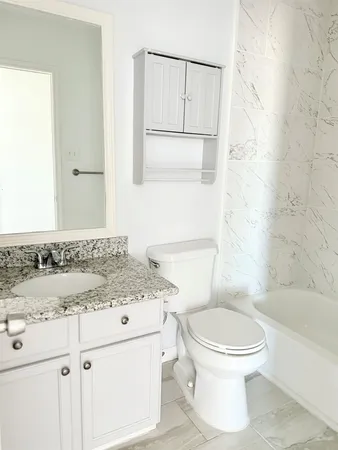 a bathroom with a sink toilet vanity and shower
