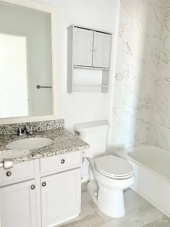 a bathroom with a sink toilet vanity and shower