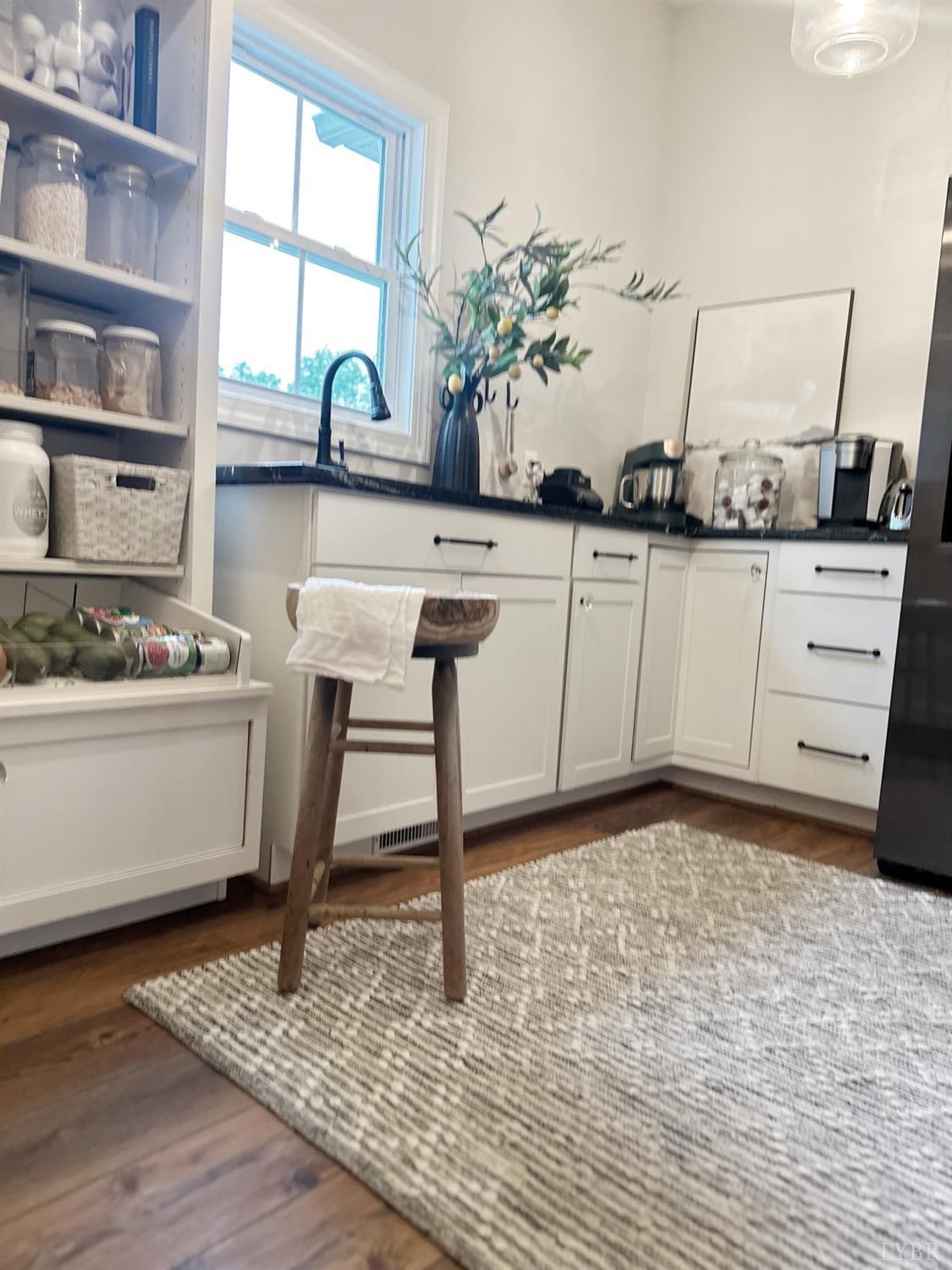 4969 Otterville Road Goode, VA 24556 - Photo 9 of 69 a view of cabinets a wooden floor and a window in the kitchen
