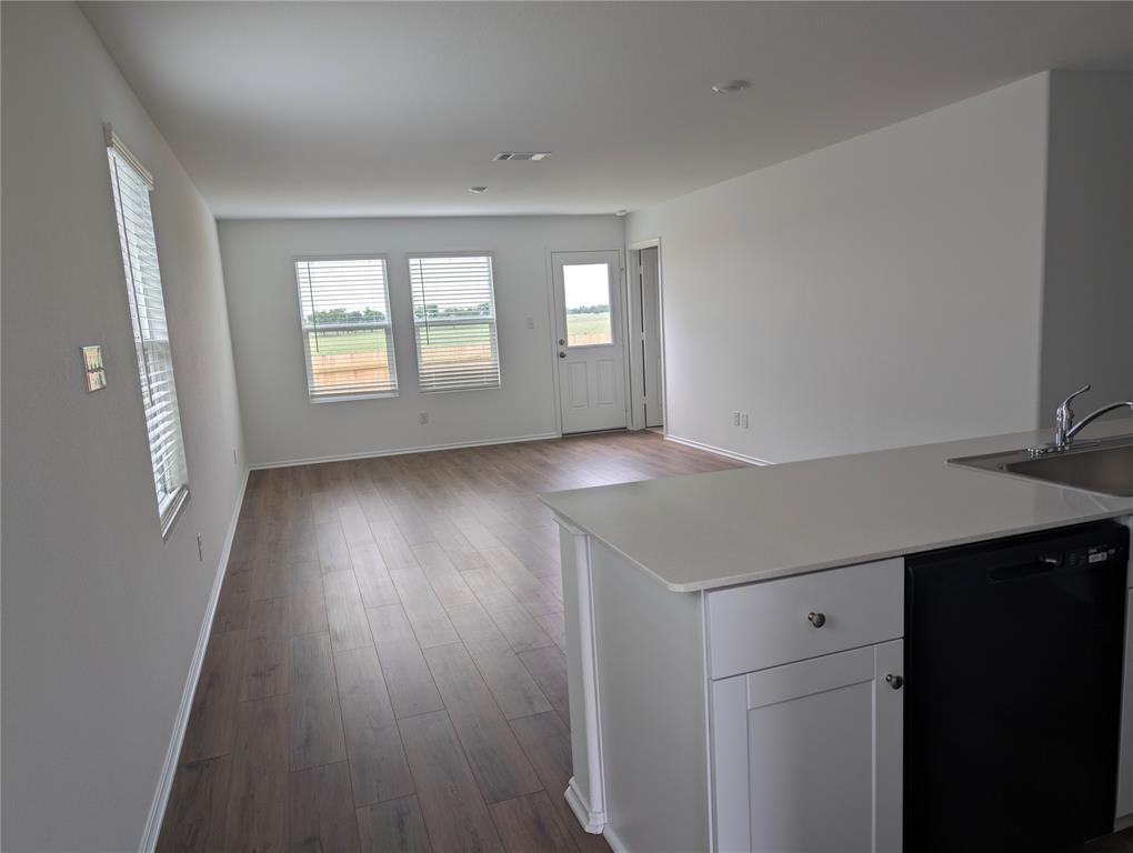 564 Rancho Del Cielo Loop Jarrell, TX 76537 - Photo 14 of 14 An open floorplan seamlessly connects the kitchen and living areas, bathed in natural light from multiple windows.