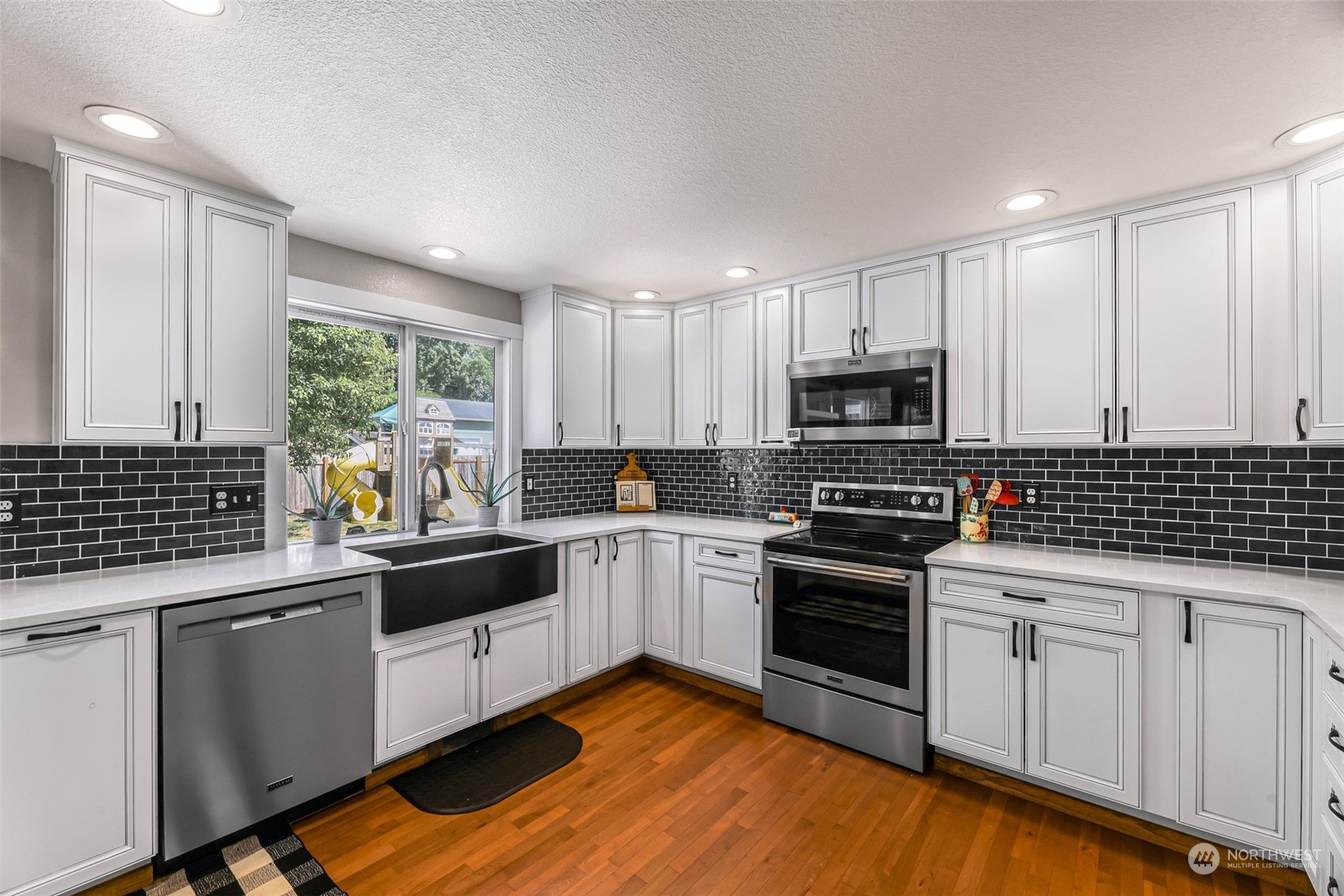 18022 Cider Court Southwest Rochester, WA 98579 - Photo 9 of 40 a kitchen with granite countertop white cabinets and appliances