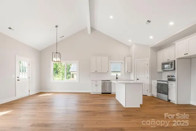 a view of kitchen view with wooden floor and stainless steel appliances