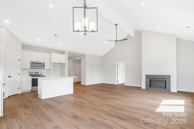 a view of kitchen with stainless steel appliances refrigerator stove microwave and cabinets