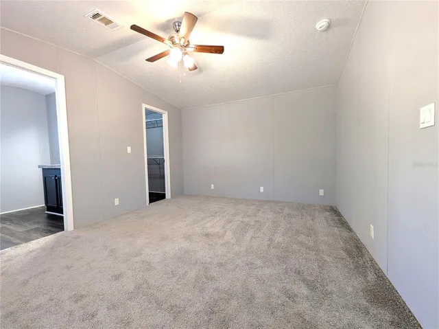 en empty room with ceiling fan and window