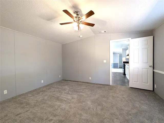an empty room with closet and ceiling fan