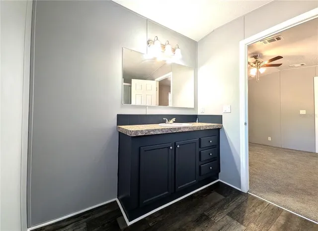 a bathroom with a granite countertop sink and a mirror