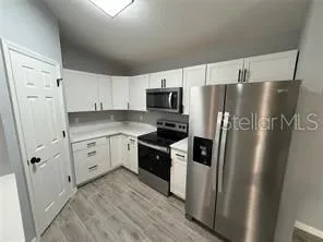 a kitchen with stainless steel appliances a refrigerator sink and microwave