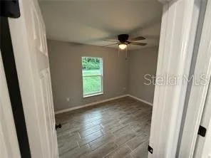 an empty room with windows and fan