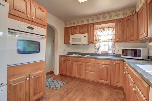a kitchen with stainless steel appliances granite countertop a stove a sink and a microwave