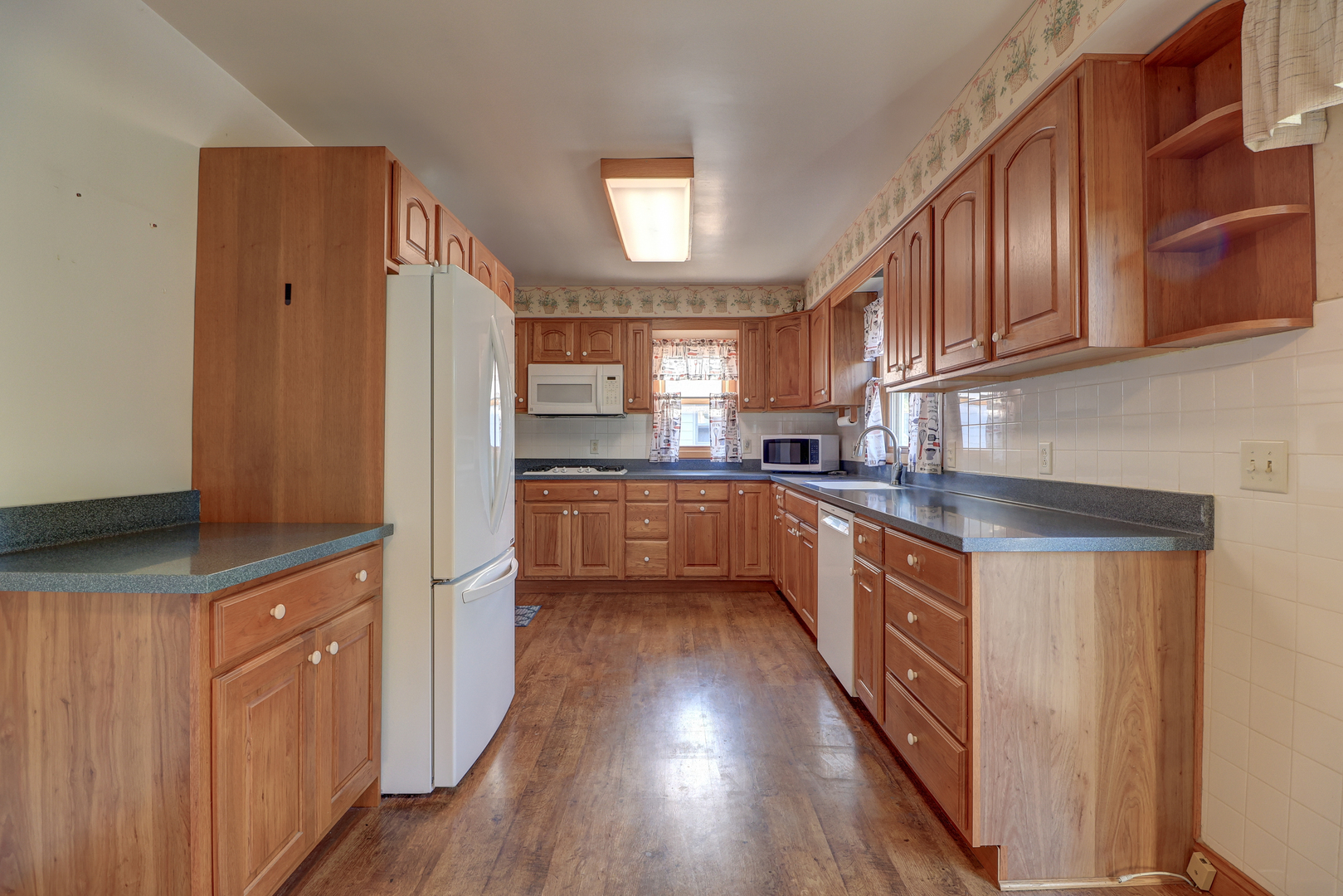 602 East 3rd Street Rock Falls, IL 61071 - Photo 10 of 22 a kitchen with stainless steel appliances granite countertop wooden cabinets a sink a stove a refrigerator and island with wooden floor