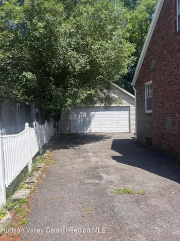 a view of a pathway of a house with wooden fence