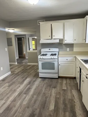 a kitchen with a stove top oven and cabinets