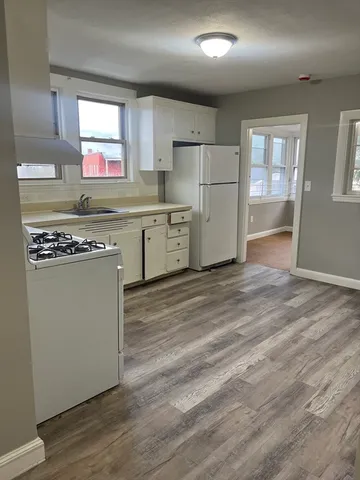 a kitchen with refrigerator cabinets and wooden floor