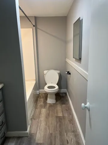 a bathroom with a toilet and a mirror