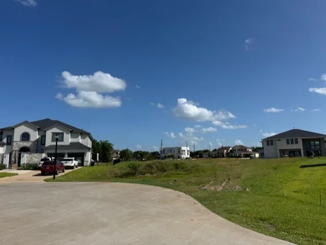 a car parked in front of a house with a big yard