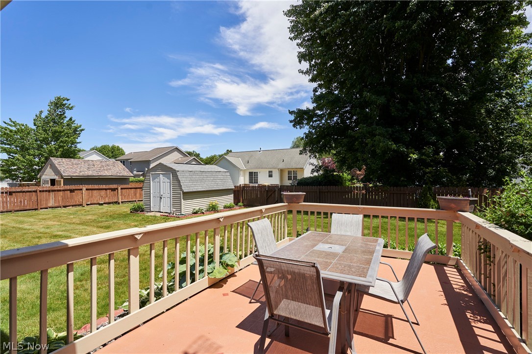 1963 Haines Road Madison, OH 44057 - Photo 32 of 34 Expansive outdoor deck with wood railing, offering a direct walkout to a green lawn