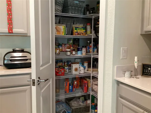 a kitchen with white cabinets and a wooden floor