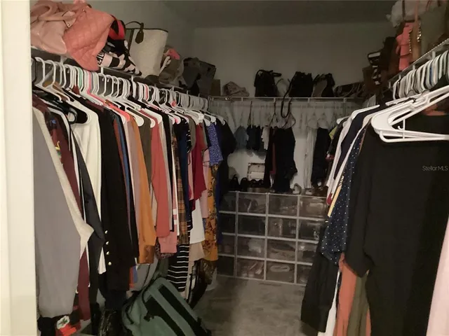 a view of walk in closet with clothes and shoes