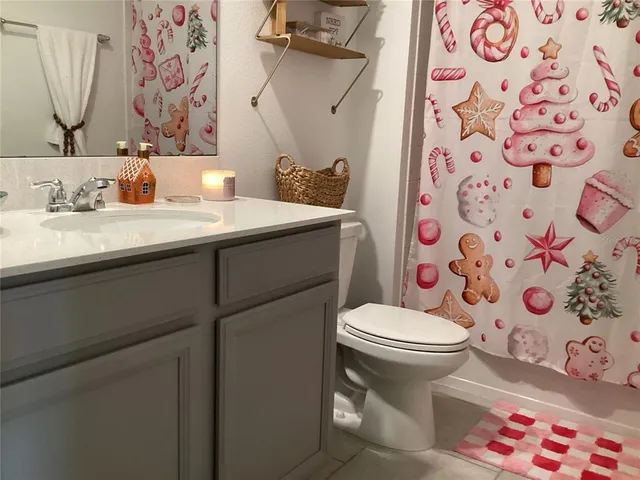 a bathroom with a sink toilet and shower curtain