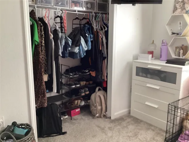 a view of walk in closet with clothes and shoes