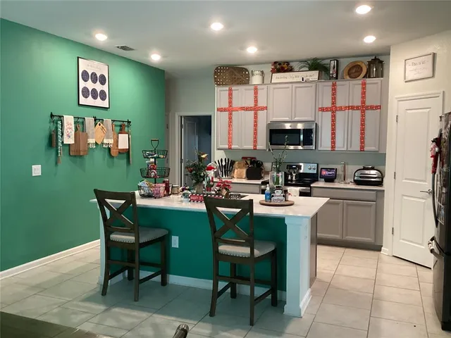 a kitchen with a dining table chairs and a refrigerator