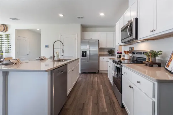 a kitchen with stainless steel appliances granite countertop a sink a stove and a refrigerator