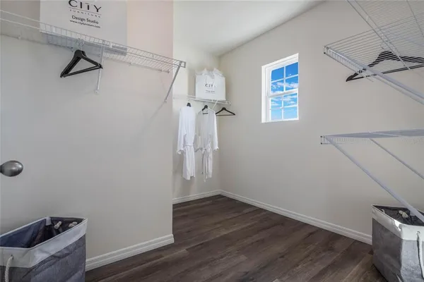 a view of a room with wooden floor and a ceiling fan