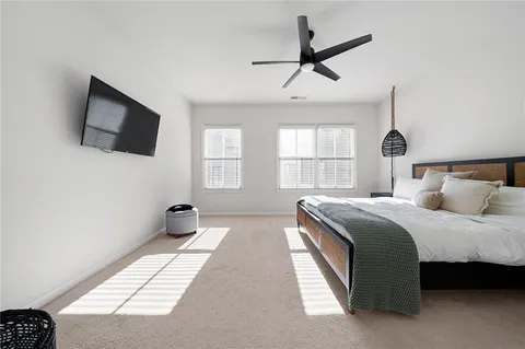 a bedroom with a large bed and a flat tv screen on dresser