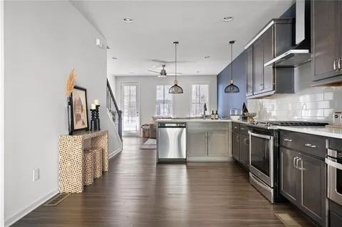 a kitchen with stainless steel appliances granite countertop a sink cabinets and wooden floor