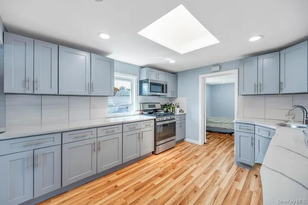 a kitchen with granite countertop white cabinets sink and stainless steel appliances