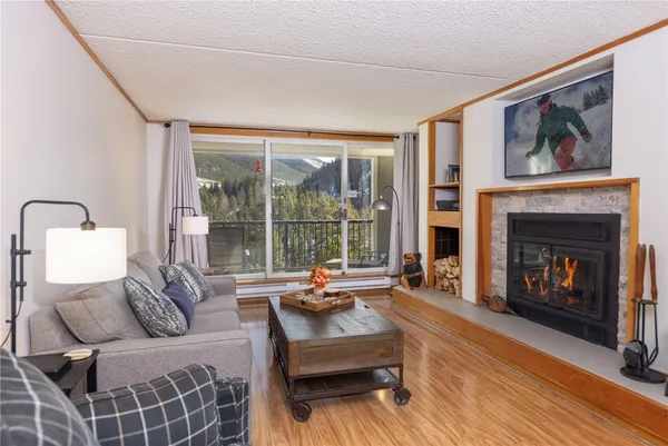 a living room with furniture large window and a fireplace