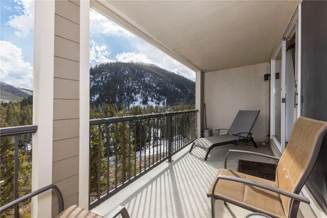 a view of a balcony with chair and wooden floor